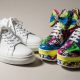 A pair of clean white sneakers placed next to bold colorful statement shoes on a neutral background