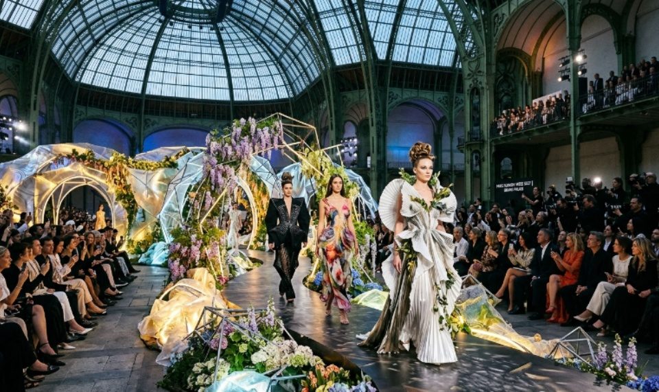 Models walk the runway at the Grand Palais during Paris Fashion Week Spring/Summer 2027, surrounded by an elaborate custom set installation.